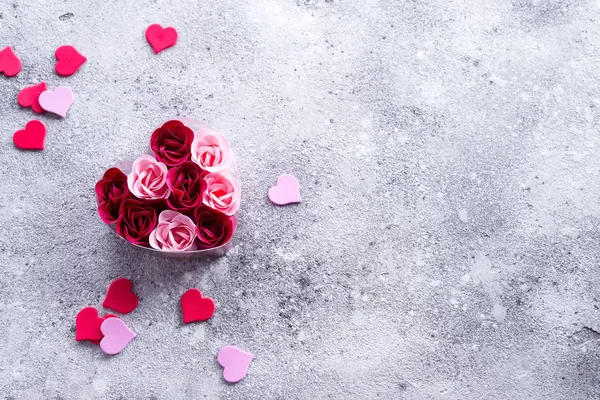Parlak pembe ve kırmızı güller sabun talaşı taş, kalp şeklinde bir kutu içinde kalpler ile yapılmış. Sevgililer spa romantik, kopya alanı — Stok fotoğraf