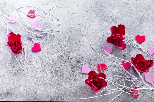 Rami nella neve con boccioli di rosa rossa e cuori su uno sfondo concreto con spazio per il testo. Concetto di San Valentino — Foto Stock
