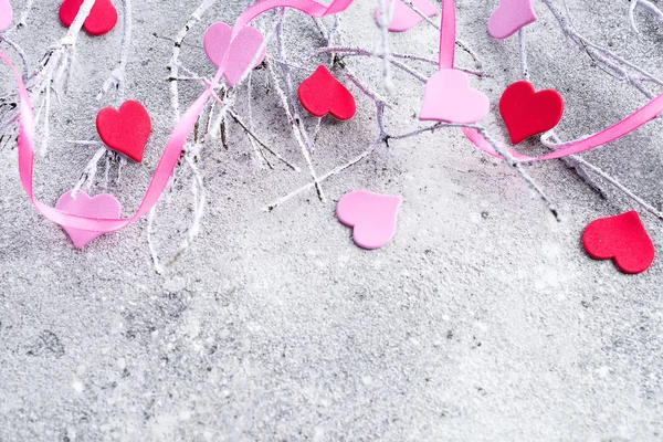 Filialer i snön med rosa och röda hjärtan på en konkret bakgrund med utrymme för text. Alla hjärtans dag koncept — Stockfoto