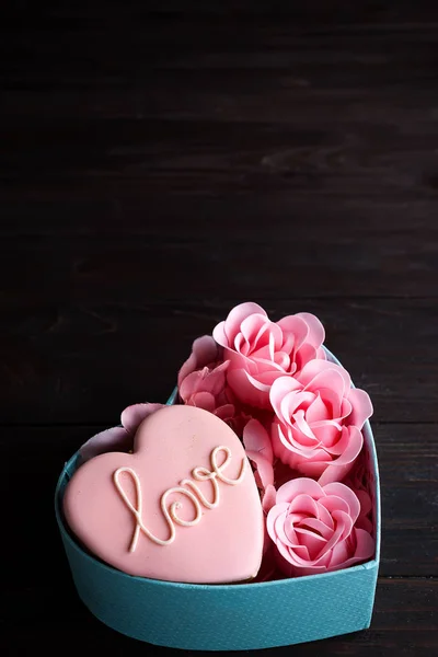 Hearts cookies in box. Festive round blue box with cookies and Rose on dark wooden background, copy space