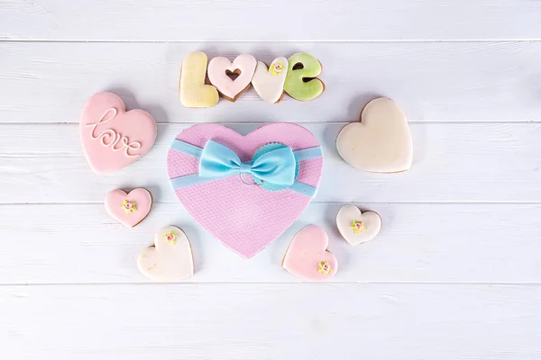 Valentýna dárkové krabičky ve tvaru srdce cookies a dekorace na bílém pozadí dřevěná. Svátek lásky pozadí — Stock fotografie