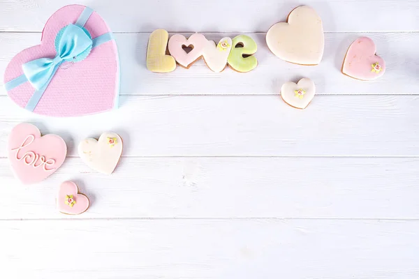 Valentýna dárkové krabičky ve tvaru srdce cookies a dekorace na bílém pozadí dřevěná. Svátek lásky pozadí — Stock fotografie