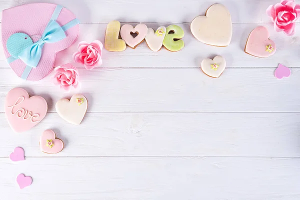 Confezioni regalo San Valentino con biscotti a forma di cuore e decorazioni su sfondo bianco in legno. Vacanza amore sfondo — Foto Stock