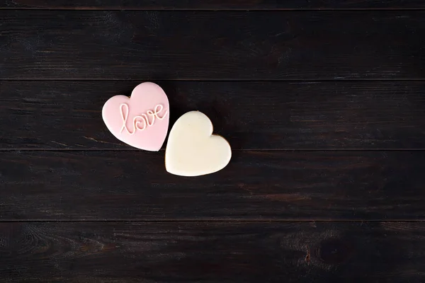 Sweets on Valentines Day. Cookies in shape of heart and with lettering Love on dark wooden background top view copy space — Stock Photo, Image