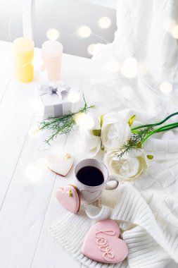 Yatakta romantik kahvaltı. Kahve, kurabiye, hediye kutusu ve çiçek ahşap masa üzerinde. Sevgililer günü kavramı