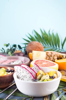 pitaya, ananas, chia tohum ve palmiye yaprağı taş zemin üzerine çilek ile kahvaltı yeşil yoğurt kase tepesinde,