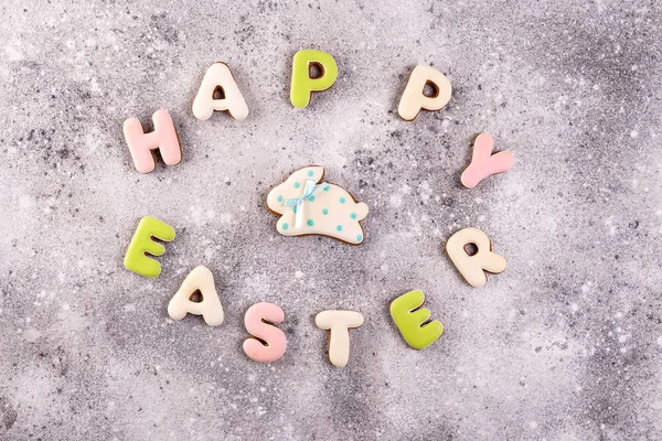 Feliz Pascua letras coloridas Feliz Pascua de galletas de jengibre y galletas conejito sobre fondo de piedra . — Foto de Stock