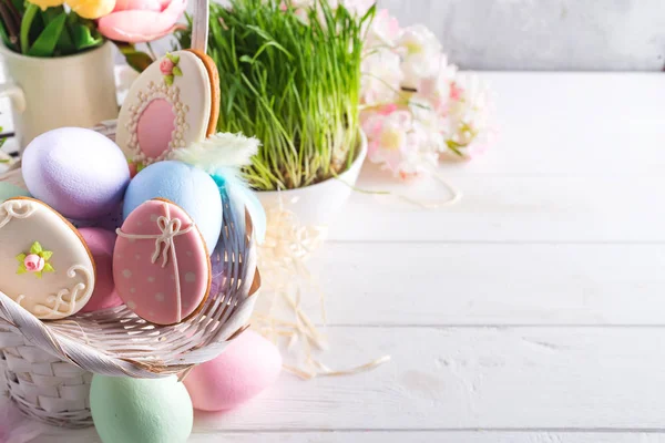 Wielkanocne z życzeniami z oszklonych ciasteczka i kolorowych pisanek w koszyku. Z miejsca kopii — Zdjęcie stockowe