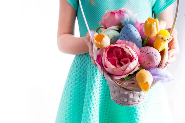 Schattig kindje houden mand met beschilderde eieren en bloemen op Paasdag. — Stockfoto