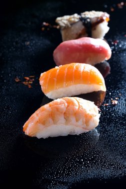 Sashimi, uramaki ve nighiri, pirinç, somon ve ton balığı, oluşan Japon yemek karides siyah su damla ile. Japon restoranı kavramı