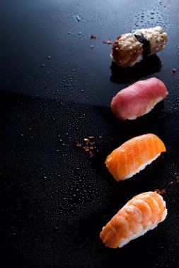 Sashimi, uramaki ve nighiri, pirinç, somon ve ton balığı, oluşan Japon yemek karides siyah su damla ile. Japon restoranı, düz kavramı kopya alanı yatıyordu
