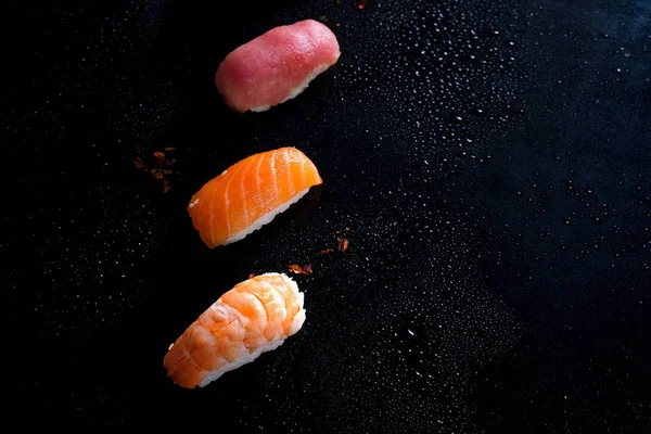 Sashimi, uramaki ve nighiri, pirinç, somon ve ton balığı, oluşan Japon yemek karides siyah su damla ile. Japon restoranı, düz kavramı kopya alanı yatıyordu