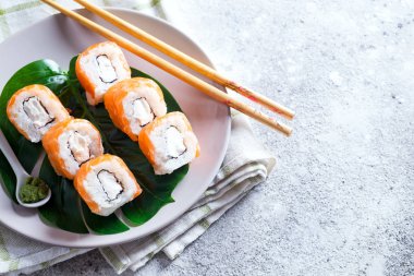 Philadelphia rulo klasik yemek çubukları ile bir tabakta. Japon suşi yemek. Kopya alanı