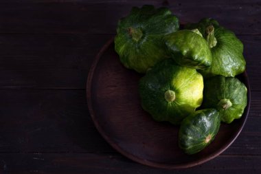 küçük boyutlu patty pan patisson kabak koyu ahşap arka plan kopya alanı ile plaka üzerinde