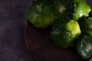 küçük boyutlu patty pan patisson kabak koyu ahşap arka plan kopya alanı ile plaka üzerinde