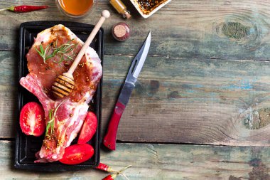 Taze çiğ et rosemary ile marine edilmiş baharatlı domuz eti, baharat ve otlar siyah arduvaz tabakta görmek yukarıda, pişmemiş kopyalama alanı