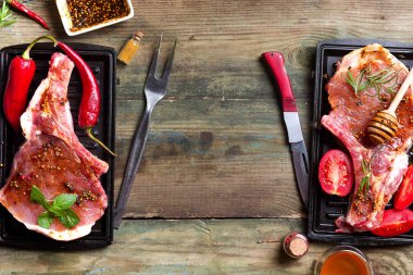 Taze çiğ et rosemary ile marine edilmiş baharatlı domuz eti, baharat ve otlar siyah arduvaz tabakta görmek yukarıda, pişmemiş kopyalama alanı