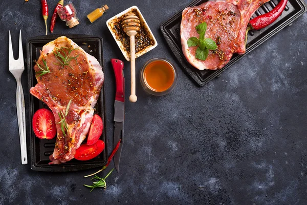 新鮮な生の牛肉、ローズマリーでマリネした豚のピリ辛肉スパイスし、ハーブ黒スレート板上を上から見る調理スペースをコピーします。 — ストック写真