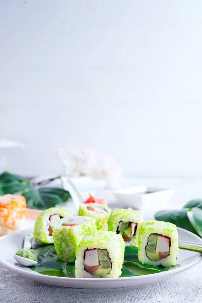 Sushi roll with green caviar on a plate with chopsticks on stone background . Sushi menu. Japanese food copy space. — Stock Photo, Image