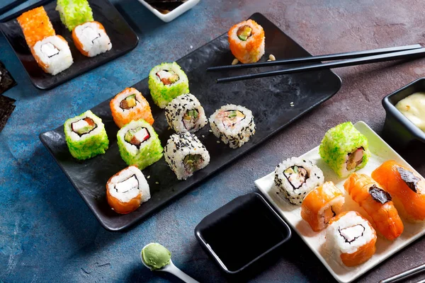 Comida tradicional japonesa: sushi, rollos, palillos, salsa de soja sobre fondo de piedra de color. Menú Sushi . — Foto de Stock