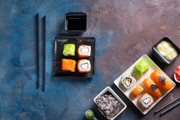 Comida tradicional japonesa: sushi, rollos, palillos, salsa de soja sobre fondo de piedra de color. Menú Sushi . — Foto de Stock