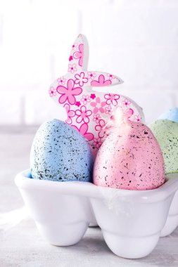 Beyaz porselen dekoratif kutusunda cutie tavşanlı organik renkli Paskalya yumurtaları. Tatil Paskalya kavramı .