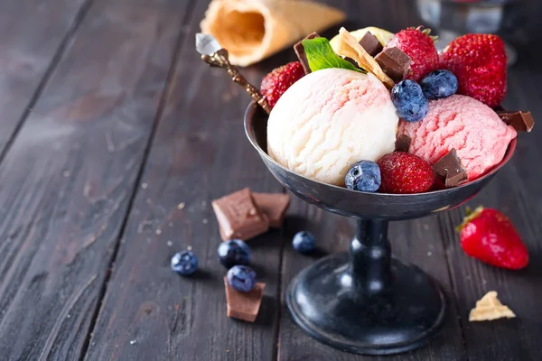 Trío de sabroso helado de limón, vainilla y fresa con sabor a postre congelado en un tazón de metal con pajitas de oblea y bayas en madera —  Fotos de Stock