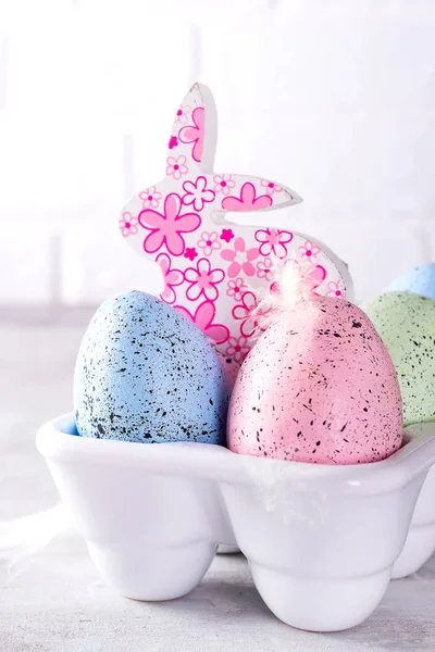 Органические красочные пасхальные яйца с милашкой кроликом в фарфоровой декоративной коробке на белом. Пасхальная концепция  . — стоковое фото