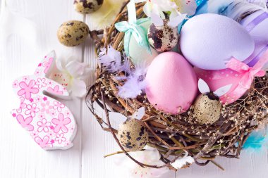 Beyaz ahşap arka planda yuva Paskalya tavşan yumurtaları, yakın yukarı, düz yatıyordu