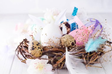 Paskalya yumurta yuvada tüy çiçekli Beyaz ahşap plakalar üzerinde ve