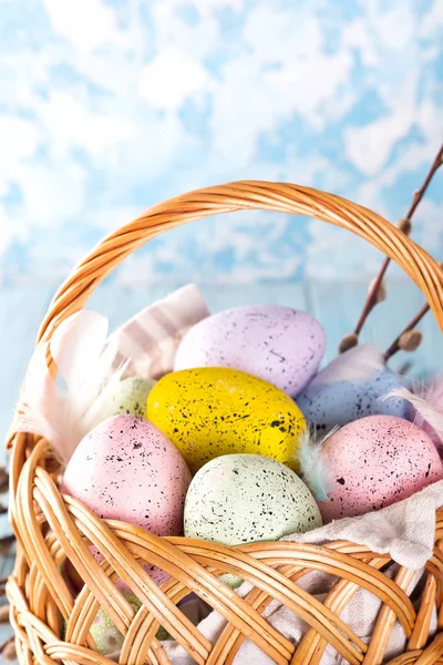 五颜六色的复活节彩蛋在篮子在蓝色木背景。特写 — 图库照片