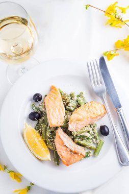 Beyaz şarap ile beyaz arka planda buğulanmış yeşil fasulye ve limon ile ızgara somon