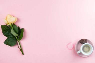 pembe bir arka plan üzerinde tek bir gül ile beyaz bir fincan espresso, düz yatıyordu kopya alanı.