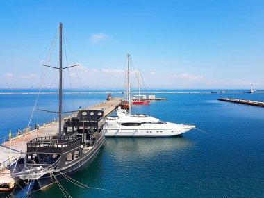 Odessa, Ukrayna. 15.03 2019. Turistler için siyah ahşap eski gemi ve Deniz limanında modern bir beyaz yat.