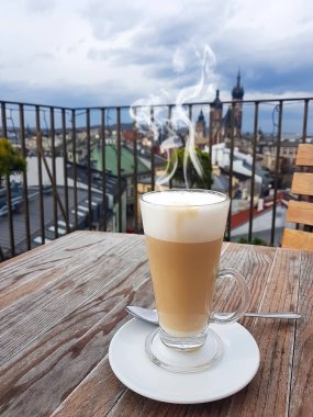 Hot coffee cup in cafe on a roof with view to St. Marys Church Krakow , Poland at the morning clipart