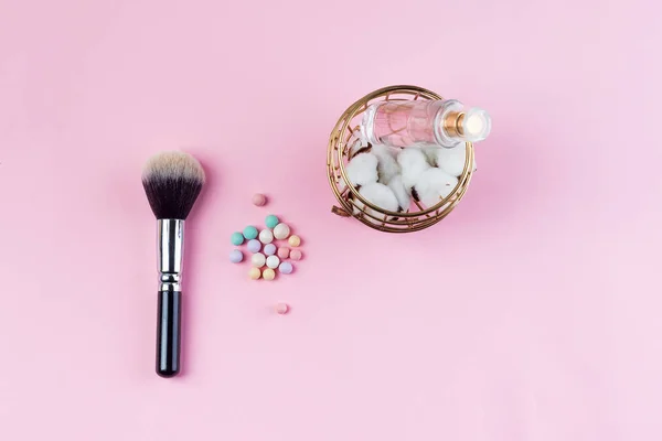 Conjunto de bolas de cosméticos coloridos de algodón, perfume y pincel sobre fondo rosa. Accesorios de maquillaje Vista superior Flat Lay —  Fotos de Stock