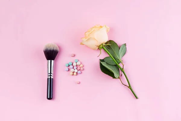 Conjunto de bolas de polvo de cosméticos coloridos y brushe con rosa sobre fondo rosa. Accesorios de maquillaje Vista superior Flat Lay —  Fotos de Stock