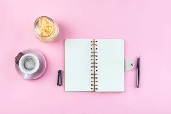 Caneca de café da manhã para café da manhã, caderno vazio, lápis e rosa na vista superior da mesa rosa. Mesa de trabalho da mulher . — Fotografia de Stock