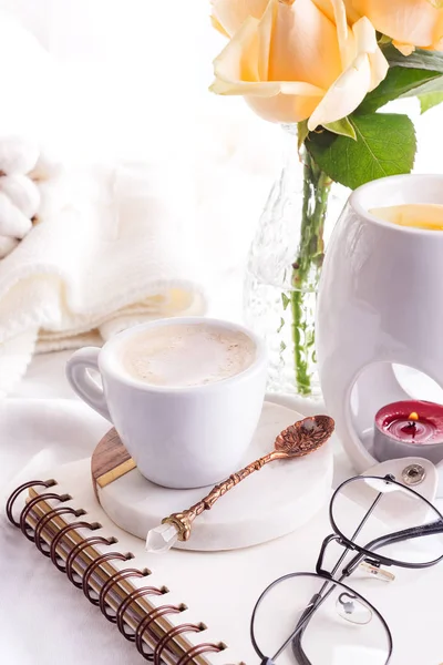 Taza de café de la mañana con vasos en un cuaderno, vela y rosa en una cama blanca vista superior. Mujer mañana acogedor — Foto de Stock