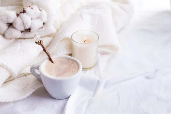 Ropa de cama con una esponjosa tela a cuadros y una taza de café, flores de algodón y velas. Un día acogedor. Piso tendido, vista superior —  Fotos de Stock