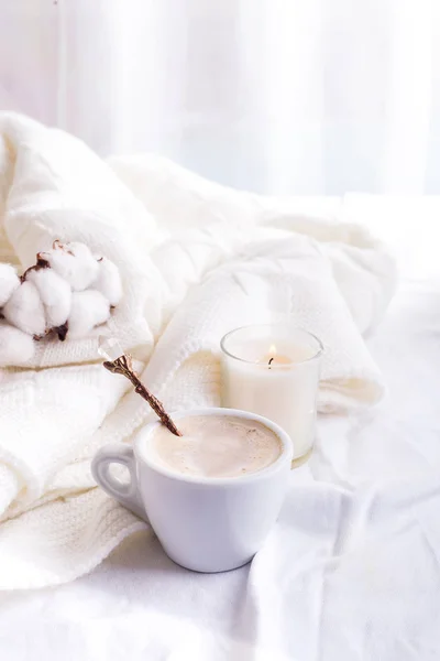 Ropa de cama con una esponjosa tela a cuadros y una taza de café, flores de algodón y velas. Un día acogedor. Piso tendido, vista superior —  Fotos de Stock