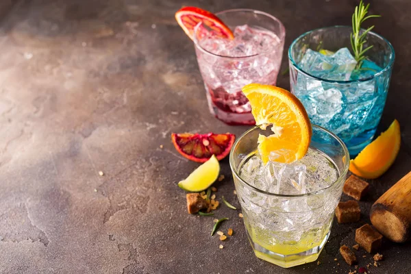 Set aus bunten Cocktails mit Früchten und Kräutern, braunem Zucker auf Steinhintergrund — Stockfoto