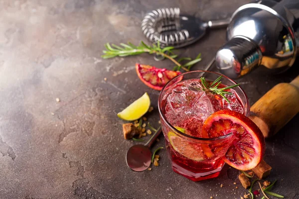 Czerwony świeży kolorowy egzotyczny koktajl alkoholowy z pomarańczowym i lodem na kamiennym tle. Czerwone kolorowe Mojito — Zdjęcie stockowe