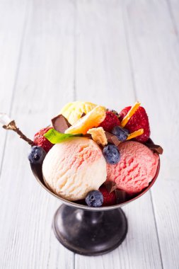 Çilek, ahşap arka plan üzerinde çikolata ile farklı renk ve tatlar dondurma kepçe seti