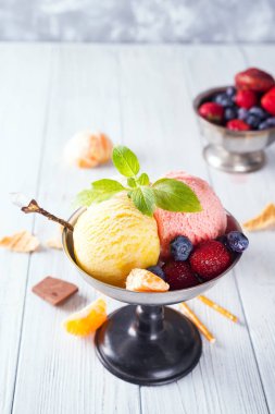 Çilek, ahşap arka plan üzerinde çikolata ile farklı renk ve tatlar dondurma kepçe seti