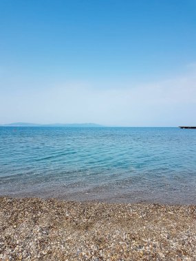 Natur su yüzeyi ve çakıl plaj . Çakıl plaj ile deniz suyu arka plan. Su yüzeyinde dalga parlaması