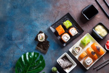 Maki rulo ve yeşil yaprakları taş masa üzerinde palmiye seti. Kopyalama alanı