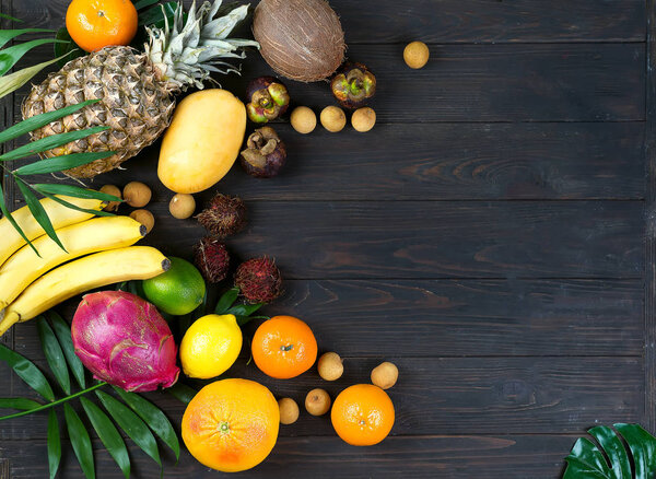 Tropical Fruits and Berry Raw Eating Diet Concept Food frame with copy space over wooden background in tropical theme