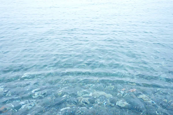 Bakgrund skott av Aqua havsvatten yta med småsten — Stockfoto