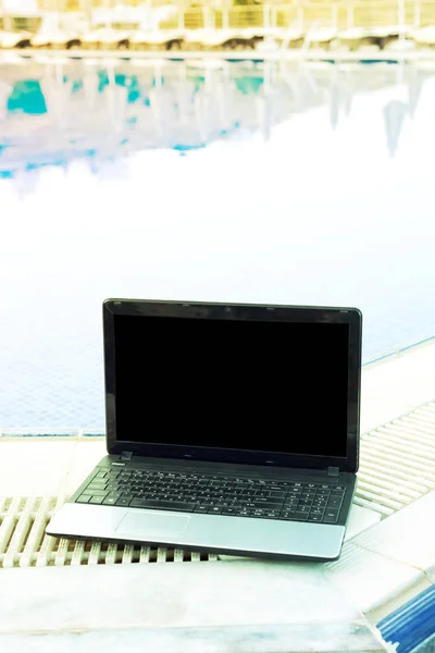 laptop at the pool, work on holiday summer concept